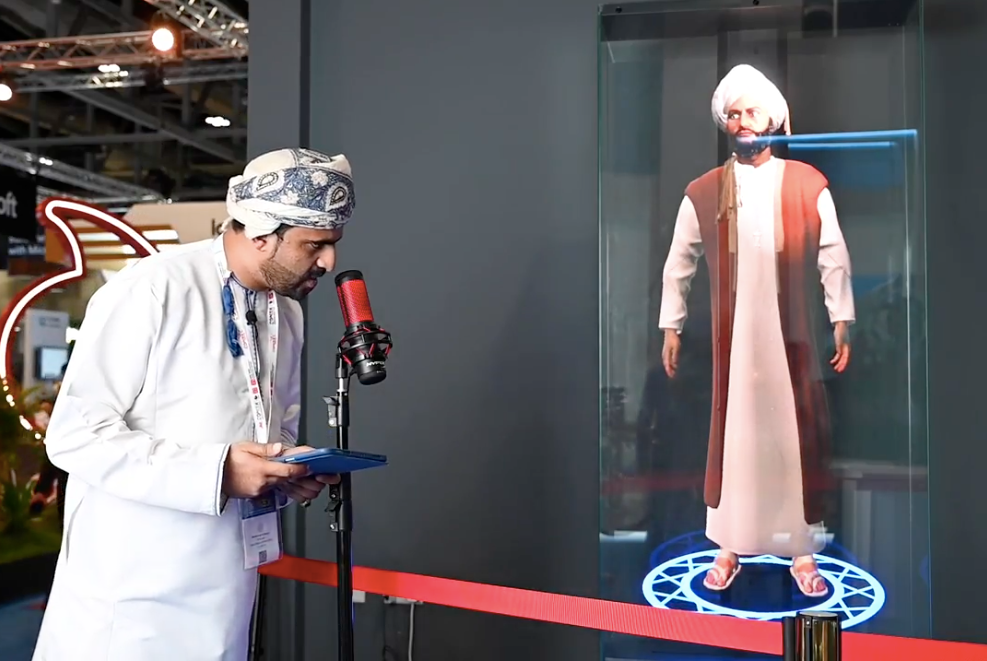The co-founder of Digital Diffusion interacts with the first 3D Holographic Omani Digital Avatar, showcasing a blend of local culture and advanced technology at a tech expo