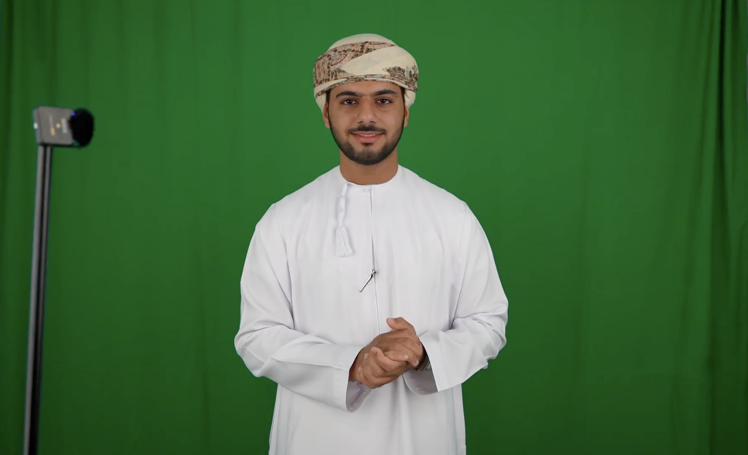 A university student in traditional Omani attire stands confidently in front of a green screen, part of Digital Diffusion’s advanced AV capture system for holographic content